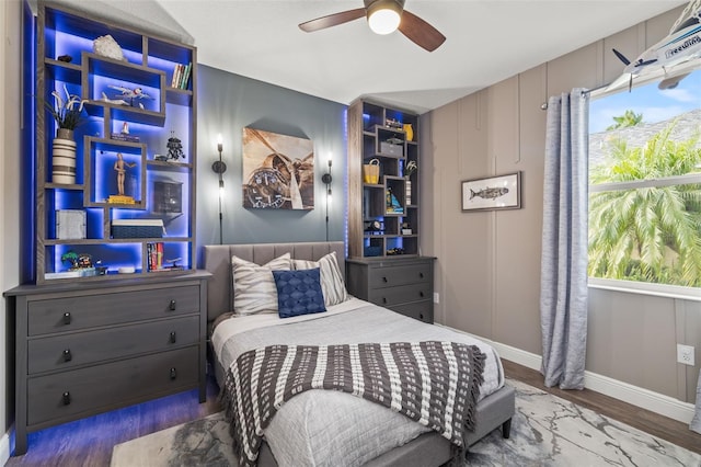 bedroom featuring wood finished floors, a ceiling fan, and baseboards