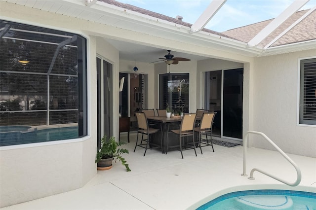 view of patio / terrace featuring a pool with connected hot tub, a ceiling fan, and outdoor dining space