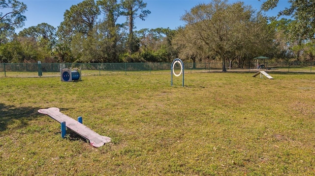 view of home's community with a yard and fence