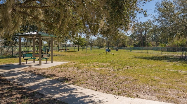 view of property's community featuring fence and a yard