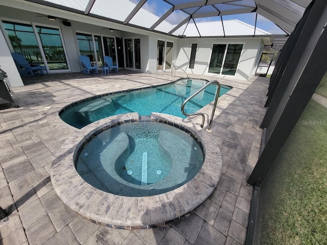 view of swimming pool featuring ceiling fan, a patio area, a lanai, and a pool with connected hot tub