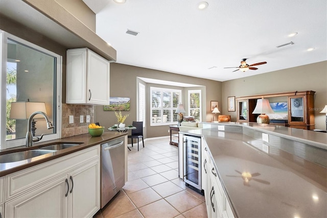 kitchen featuring sink, dishwasher, white cabinetry, backsplash, and wine cooler