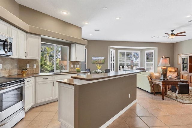 kitchen featuring sink, white cabinetry, tasteful backsplash, a kitchen island, and stainless steel appliances