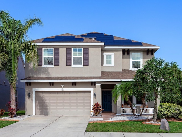 view of front of property with a porch, a garage, and solar panels