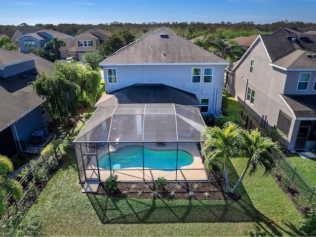 view of swimming pool with a fenced in pool, glass enclosure, a fenced backyard, and a yard