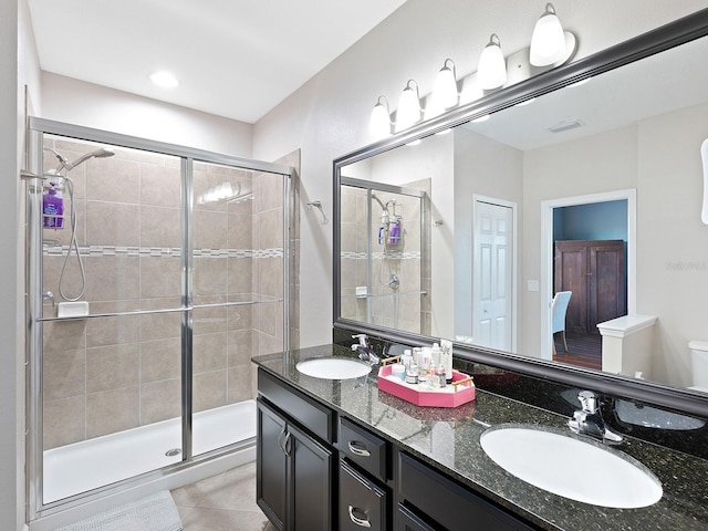 full bath with a stall shower, a sink, and tile patterned floors