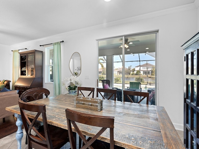 dining space featuring crown molding, light tile patterned flooring, and ceiling fan