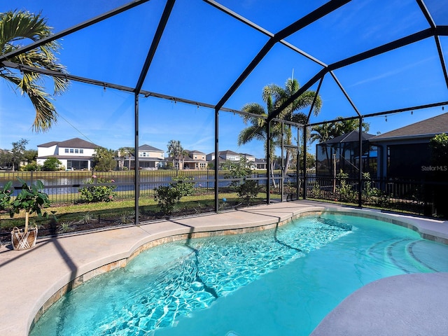 view of swimming pool featuring a fenced in pool, a patio, glass enclosure, a residential view, and fence