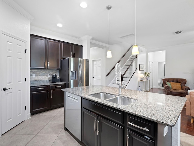 kitchen featuring light tile patterned floors, visible vents, appliances with stainless steel finishes, open floor plan, and a sink