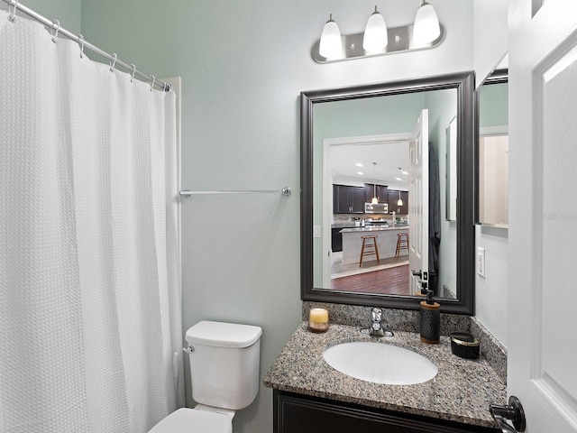 bathroom with toilet, a shower with curtain, and vanity