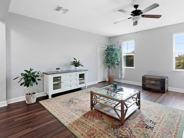 living room with baseboards, wood finished floors, visible vents, and a healthy amount of sunlight