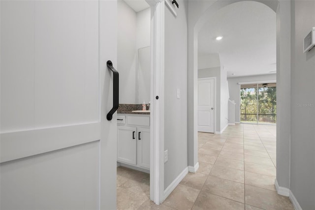 corridor with light tile patterned flooring and sink