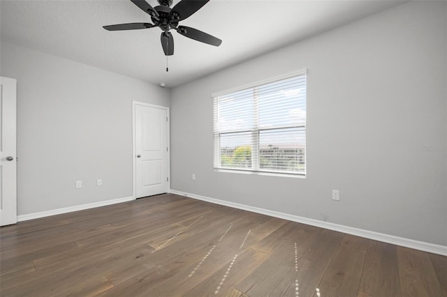 empty room featuring ceiling fan and dark hardwood / wood-style flooring