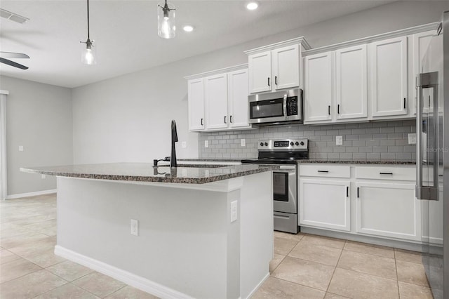 kitchen featuring sink, appliances with stainless steel finishes, white cabinetry, hanging light fixtures, and an island with sink