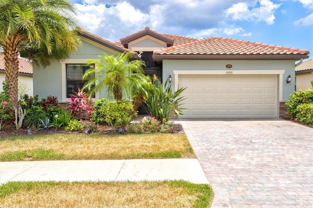 mediterranean / spanish-style house featuring a garage and a front lawn