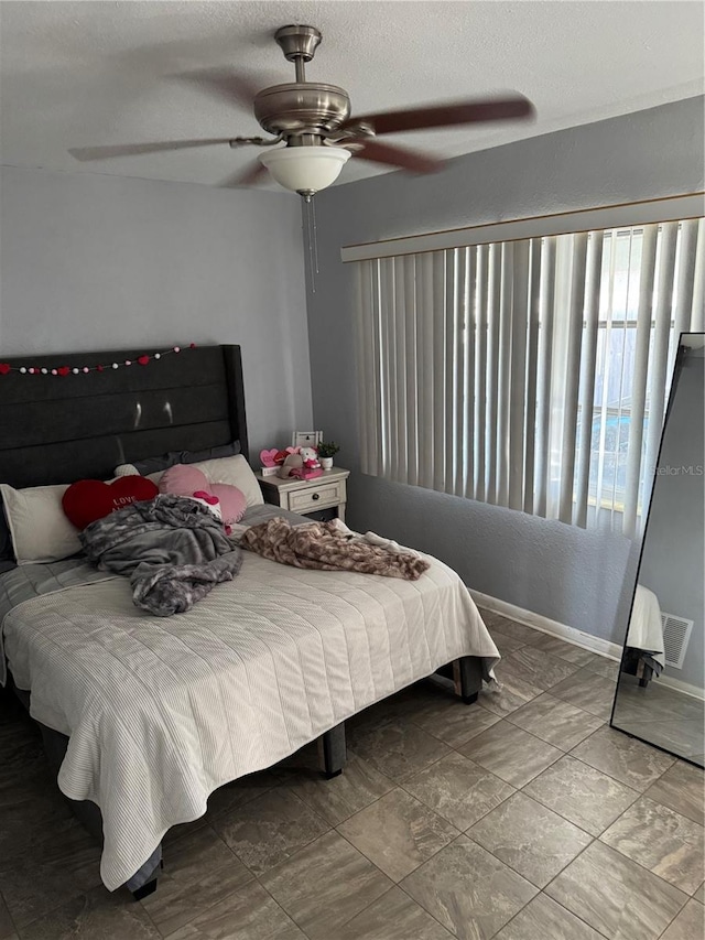 bedroom featuring a textured ceiling and ceiling fan