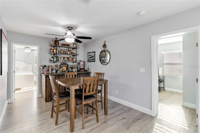 dining space with ceiling fan and light hardwood / wood-style floors