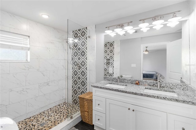 bathroom with vanity, ceiling fan, and tiled shower