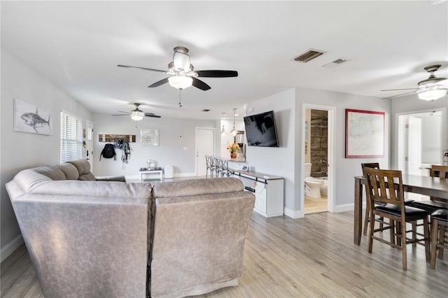 living room featuring ceiling fan and light wood-type flooring