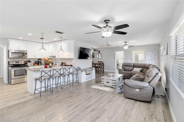 living room with sink and light hardwood / wood-style floors