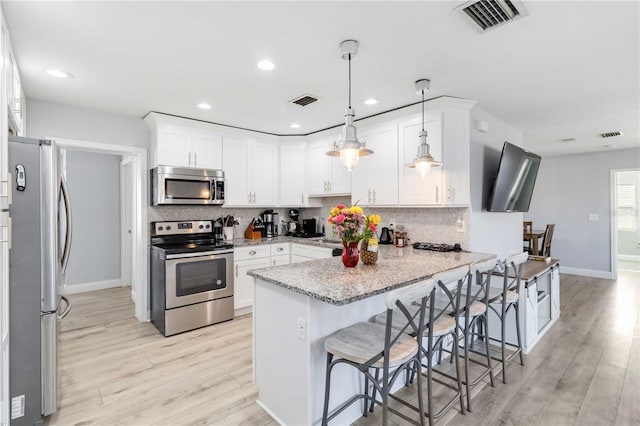 kitchen with white cabinetry, stainless steel appliances, and a breakfast bar