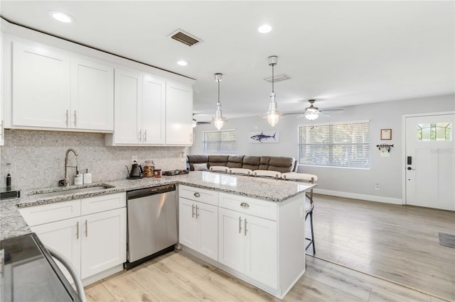 kitchen featuring white cabinetry, dishwasher, and kitchen peninsula