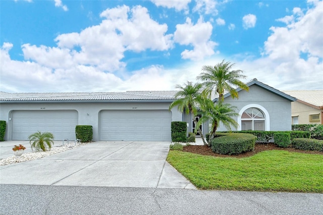 single story home featuring a garage and a front lawn