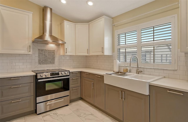 kitchen featuring white cabinetry, gray cabinetry, wall chimney range hood, and electric stove