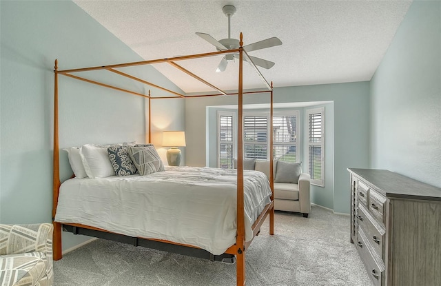 bedroom featuring vaulted ceiling, light carpet, ceiling fan, and a textured ceiling