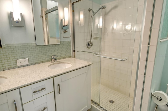 bathroom featuring vanity, an enclosed shower, and decorative backsplash