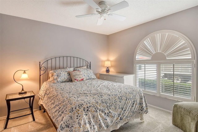 carpeted bedroom featuring ceiling fan and a textured ceiling