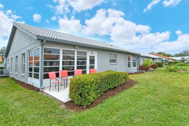 rear view of house featuring a yard and a patio