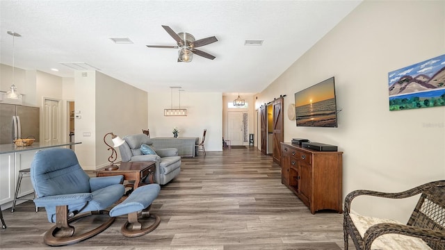 living room with a textured ceiling, light hardwood / wood-style flooring, and ceiling fan