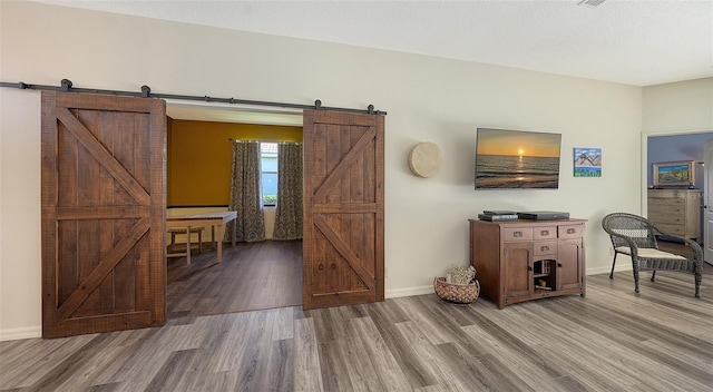 interior space featuring wood-type flooring and a barn door