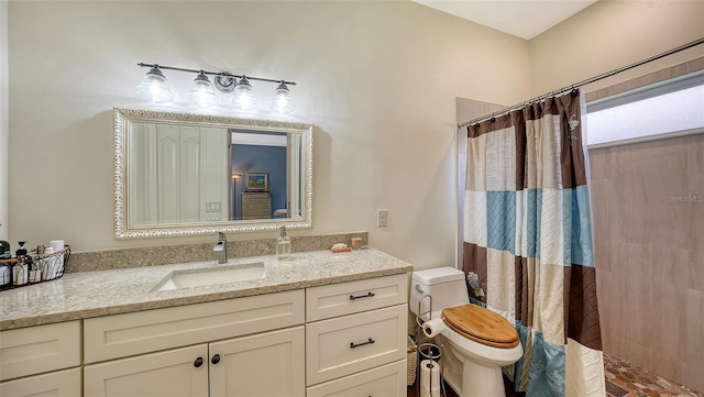 bathroom with toilet, vanity, and a shower with shower curtain