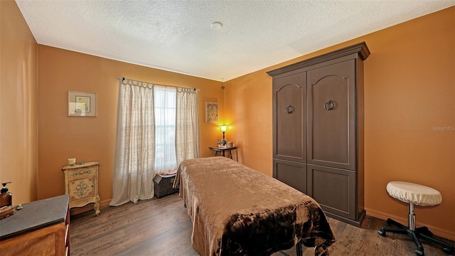 bedroom featuring dark wood-type flooring and a textured ceiling