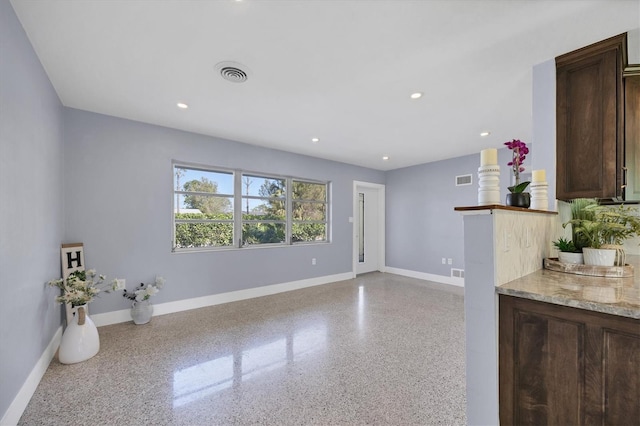 interior space with dark brown cabinetry and light stone countertops