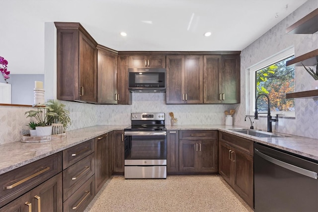 kitchen featuring light stone counters, stainless steel appliances, sink, and dark brown cabinets