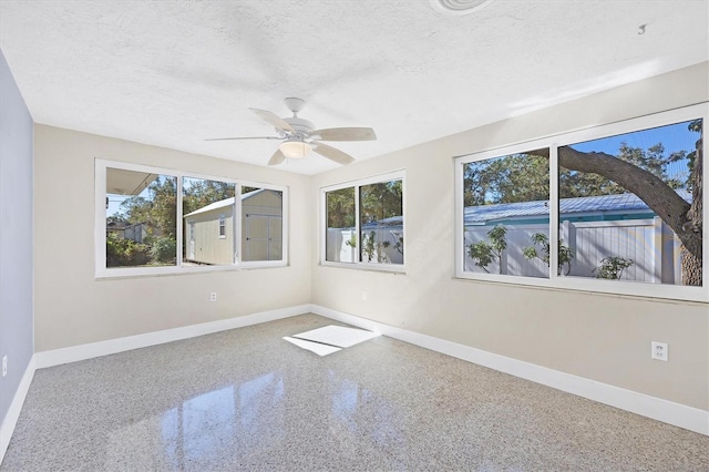 unfurnished room featuring ceiling fan and a textured ceiling