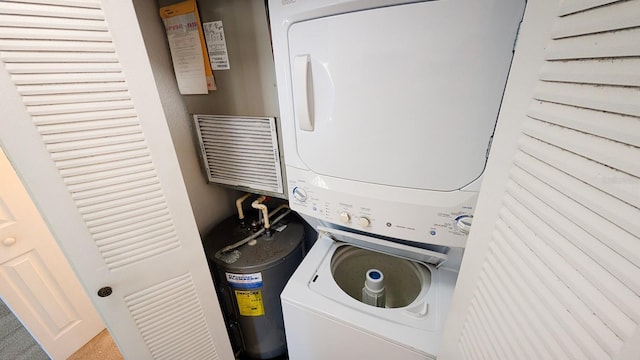 laundry room with water heater and stacked washer and clothes dryer