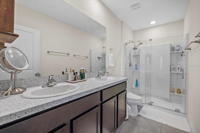 bathroom featuring tile patterned flooring, vanity, a shower with door, and toilet