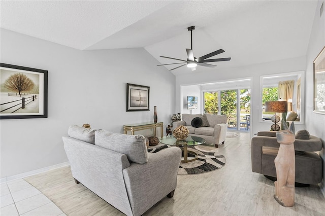 living room featuring ceiling fan, lofted ceiling, and a textured ceiling