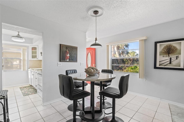 dining space with light tile patterned floors and a textured ceiling