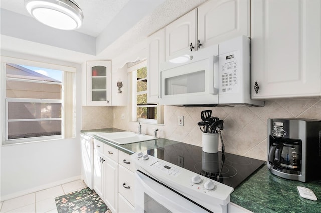 kitchen with sink, white cabinetry, light tile patterned floors, white appliances, and decorative backsplash