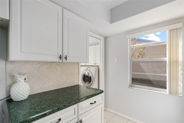 kitchen with white cabinetry, washer / dryer, and tasteful backsplash