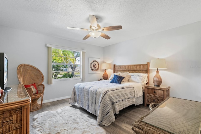 bedroom with ceiling fan, wood-type flooring, and a textured ceiling