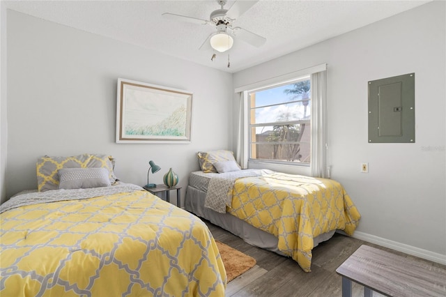 bedroom featuring ceiling fan, dark wood-type flooring, electric panel, and a textured ceiling