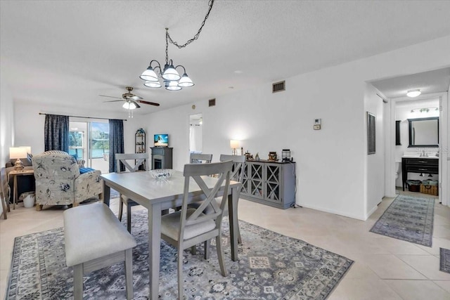 tiled dining area featuring a textured ceiling and ceiling fan