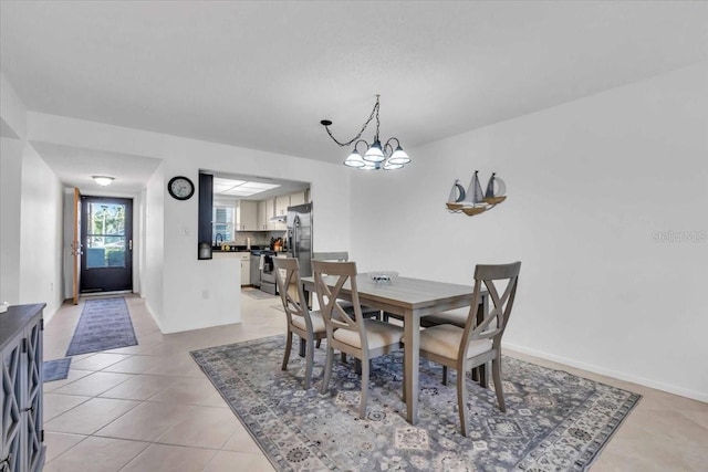 dining area featuring a notable chandelier and light tile patterned floors