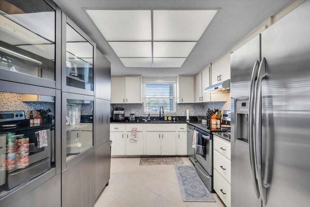 kitchen with white cabinetry, stainless steel appliances, sink, and decorative backsplash